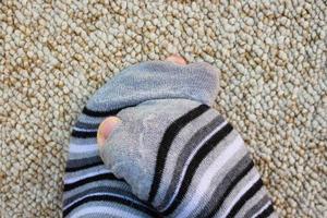 Closeup of striped socks full of holes photo