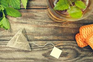 Tea bag, mint, cookie and cup of tea. Toned image. Top view. photo