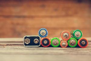 Many batteries on old wood background. Toned image photo