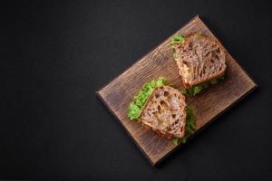 Delicious sandwich with crispy toast, chicken, tomatoes and lettuce photo