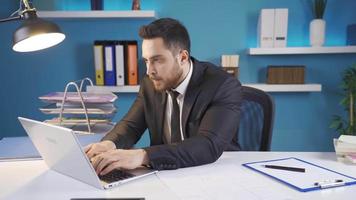 un' occupato uomo d'affari prende arrabbiato quando lui fa un' errore. uomo d'affari Lavorando a partire dal il computer portatile diventa aggressivo nel il viso di il suo errore. video