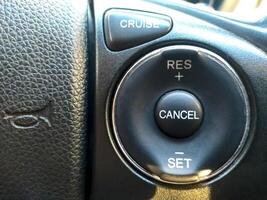 Cruise control button in conventional modern car. Car instrument panel, interior dashboard control. photo