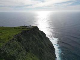 Breathtaking view of towering cliffs with lighthouse and ocean in Madeira, Portugal photo