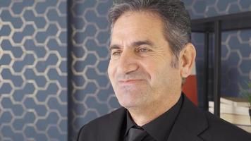 Positive mature businessman rejoices and is happy. Businessman in a good mood is succeeding and smiling congratulating himself. video