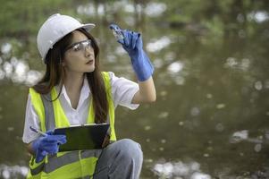 los ingenieros ambientales inspeccionan la calidad del agua, llevan el agua al laboratorio para su análisis, verifican el contenido de minerales en el agua y el suelo, verifican los contaminantes en las fuentes de agua. foto