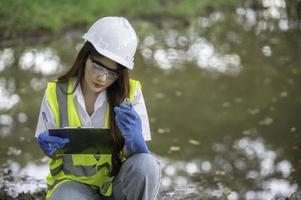 los ingenieros ambientales inspeccionan la calidad del agua, llevan el agua al laboratorio para su análisis, verifican el contenido de minerales en el agua y el suelo, verifican los contaminantes en las fuentes de agua. foto