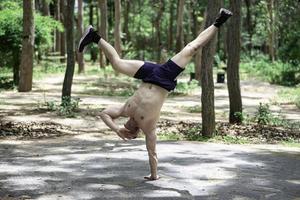 Handsome Handsome man exercises by hanging on a bar outdoor, Asian man trains for sporting eventsman exercises by hanging on a bar outdoor, Asian man trains for sporting events photo