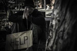 un hombre asiático no tiene hogar en la calle lateral, un extraño tiene que vivir solo en la calle porque no tiene familia. foto