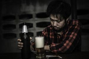 Asian man drink vodka alone at home on night time,Thailand people,Stress man drunk concept photo