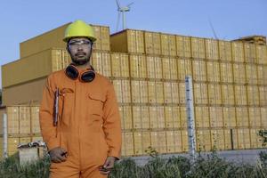 Engineer working at place for keep container,Foreman wearing hardhat standing at the container yard and Check container integrity photo