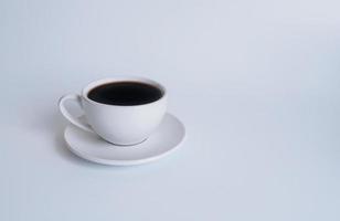 fotografía de la vista superior de la taza de café con leche en un plato blanco el interior del vaso parece vacío. esperando que se rellene el café caliente para beber para sentirse renovado y alerta sobre un fondo blanco. foto