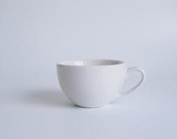 fotografía de la vista superior de la taza de café con leche en un plato blanco el interior del vaso parece vacío. esperando que se rellene el café caliente para beber para sentirse renovado y alerta sobre un fondo blanco. foto
