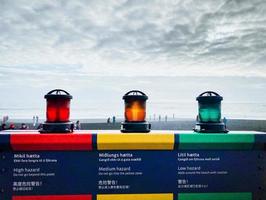 Vik, Iceland - Reynisfjara black sand beach new alarm system with flashing lights indicators level of danger on the beach. High medium and extreme hazard danger safety warning system photo