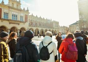 Krakow, Poland,  2023 - guide with tour group in main square in Krakow. Free tourist walking tours with locals. Unique experience in new city. Knowledgeable local guides. photo