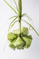 Ketupat lebaran is a typical Indonesian food during the festive season of Ketupat, Eid al Fitr, Eid al Adha, natural rice wrap made from young coconut leaves on a white background, empty space photo