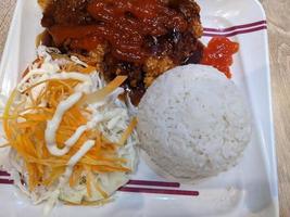 Close up photo of spicy chicken lava with cheese sauce and rice on restaurant. The photo is suitable to use for food background, poster and food content.