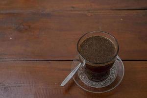 Close up photo a cup of arabica coffee with spoon from high angle. The photo is suitable to use for coffee shop background, menu poster and coffee content media.