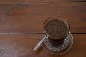 Close up photo a cup of arabica coffee with spoon from high angle. The photo is suitable to use for coffee shop background, menu poster and coffee content media.