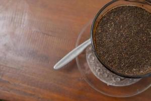 Close up photo a cup of arabica coffee with spoon from high angle. The photo is suitable to use for coffee shop background, menu poster and coffee content media.