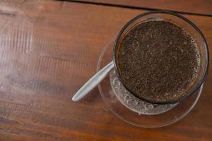 Close up photo a cup of arabica coffee with spoon from high angle. The photo is suitable to use for coffee shop background, menu poster and coffee content media.