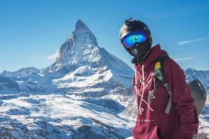 Young snowboarder spending winter holidays in Zermatt, near the famous Matterhorn peak. Male posing in Swiss Alps for the snowboarding season. photo