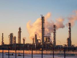 Oil refinery behind the fence in the evening at sunset photo