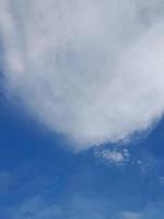 Beautiful white clouds on deep blue sky background. Large bright soft fluffy clouds are cover the entire blue sky. photo