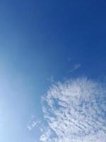 hermosas nubes blancas sobre fondo de cielo azul profundo. grandes nubes esponjosas suaves y brillantes cubren todo el cielo azul. foto