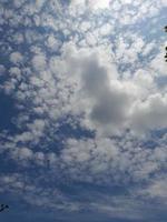 Beautiful white clouds on deep blue sky background. Large bright soft fluffy clouds are cover the entire blue sky. photo