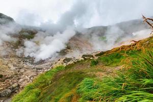 Thrilling view of volcanic landscape, aggressive hot spring, erupting fumarole, gas-steam activity in crater of active volcano photo