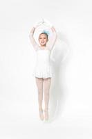 Girl ballerina in white ballet tutu skirt dancing on white background photo