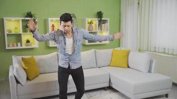 Funny clumsy young man loses balance and falls while dancing at home. Fun and cheerful young man dancing at home loses his balance and falls to the ground, Clumsy young man. video