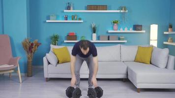 Strong man builds body with the help of dumbbells at home. Bodybuilder man exercising at home using dumbbells. video