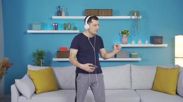 el hombre quien empezado bailando y haciendo gracioso se mueve después jugando En Vivo música en su teléfono. video