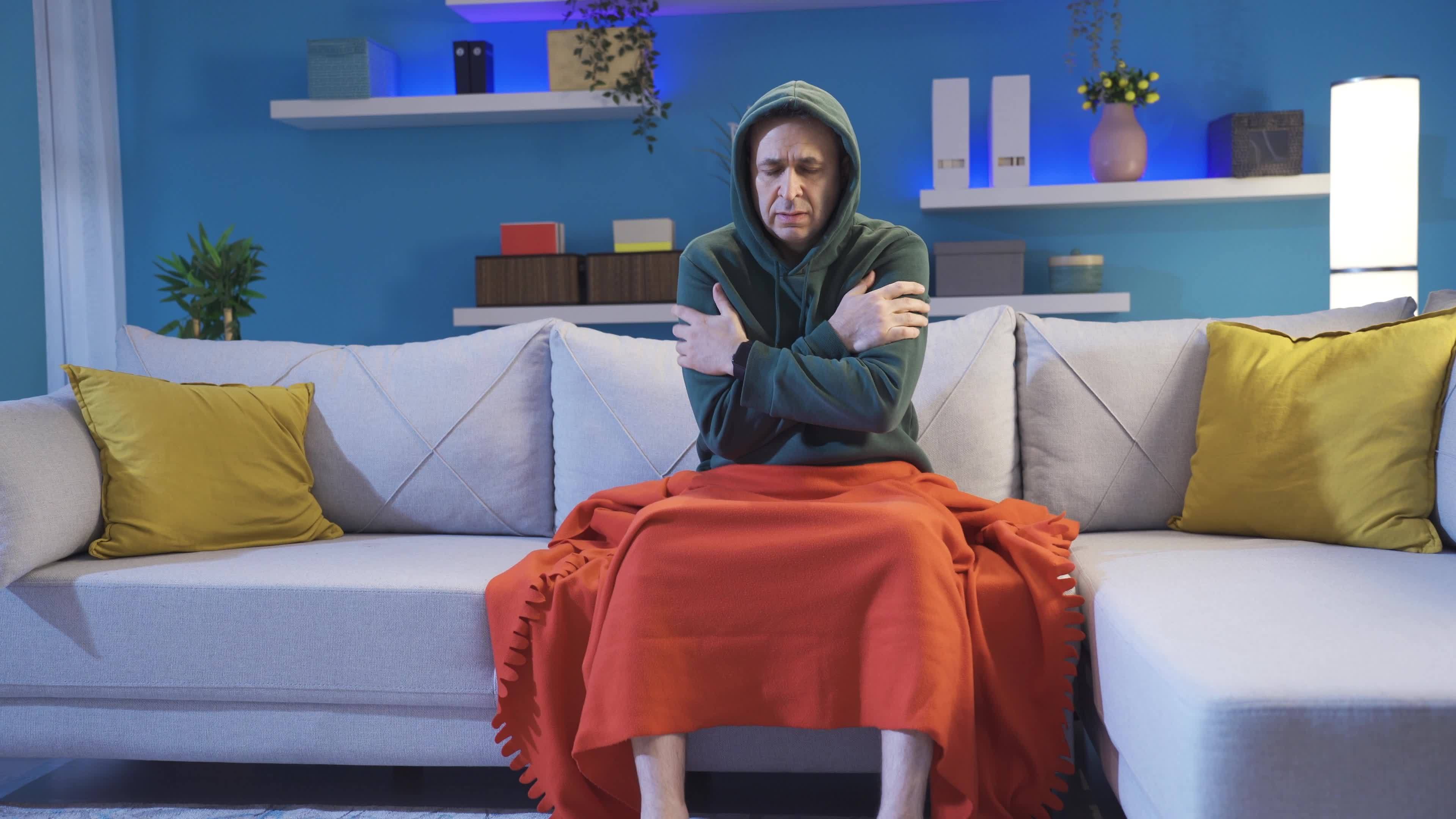 Sick man with low body temperature in cold house does not feel well