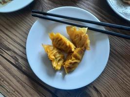 dimsum servido calentar en un blanco plato con salsa. foto