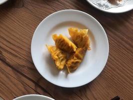 dimsum served warm on a white plate with sauce. photo