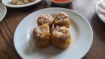 dimsum servido calentar en un blanco plato con salsa. foto