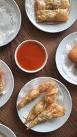 Pangsit, Pangsit Goreng, delicious Pangsit Ayam Goreng or Chicken Fried Dumpling, Indonesia Traditional Food made from flour and chicken, served on white sauce. photo