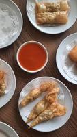 Pangsit, Pangsit Goreng, delicious Pangsit Ayam Goreng or Chicken Fried Dumpling, Indonesia Traditional Food made from flour and chicken, served on white sauce. photo