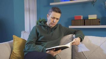 Mature man reading a book alone at home. Man reading a book in his peaceful home, enjoying his free time. video