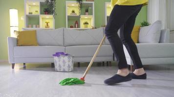 The young clumsy man cleaning the house carelessly and unconsciously slips on the wet floor and falls to the ground hard. video