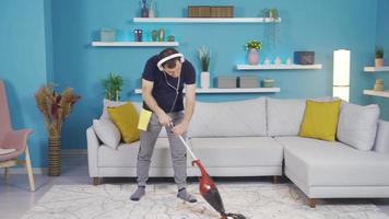 le homme est nettoyage le sien maison et tout de une soudain il est en utilisant le sien balai dans une microphone et en chantant. video