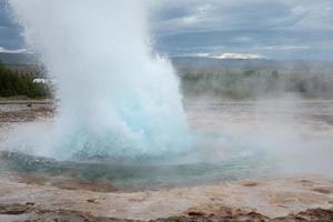 Geyser in Iceland with spouting hot springs photo
