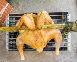 The chicken is grilled on the charcoal stove. photo