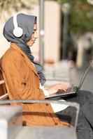 Muslim woman using a laptop in the steet photo