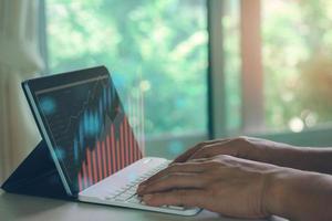 Business man hand typing keyboard to checking stock market on internet. photo