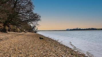 Shingle river bank at dusk photo