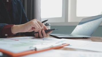 Teamwork of asian business people discussing and calculating with calculator on evaluation data in conference room. with the growth and pointing to the chart graph financial account. video