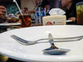 A spoon and fork on a white plate photo